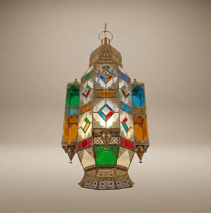 A majestic handcrafted Moroccan brass lantern with colorful stained glass hanging in the Sahara Import gallery in Oakland, casting vibrant light and intricate shadow patterns on the ceiling.