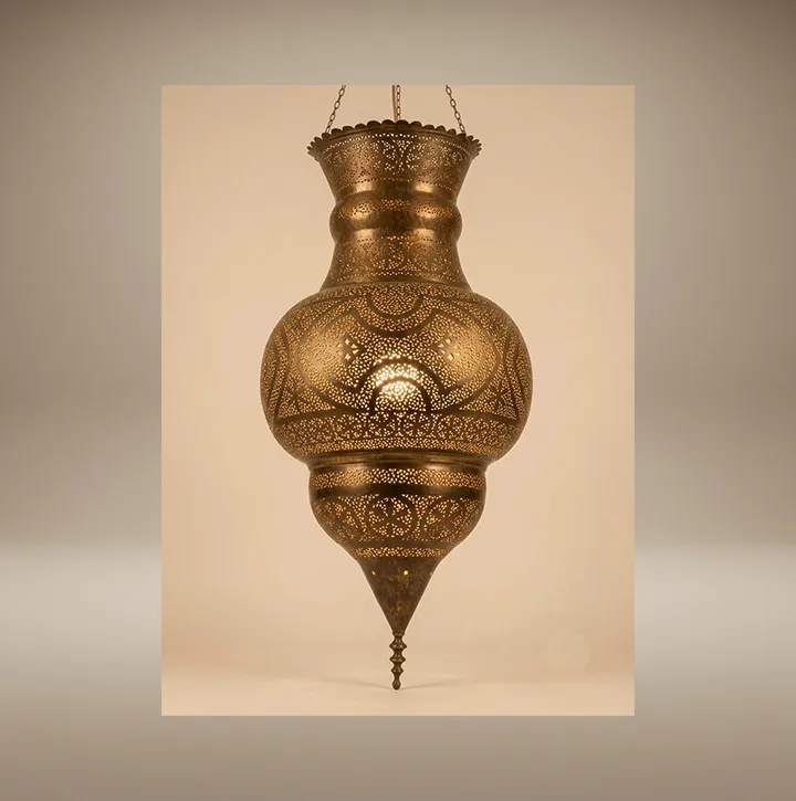 Large handcrafted Moorish brass lantern featuring intricate hand-pierced filigree work, casting mesmerizing geometric light patterns on the ceiling at the Sahara Import gallery in Oakland.